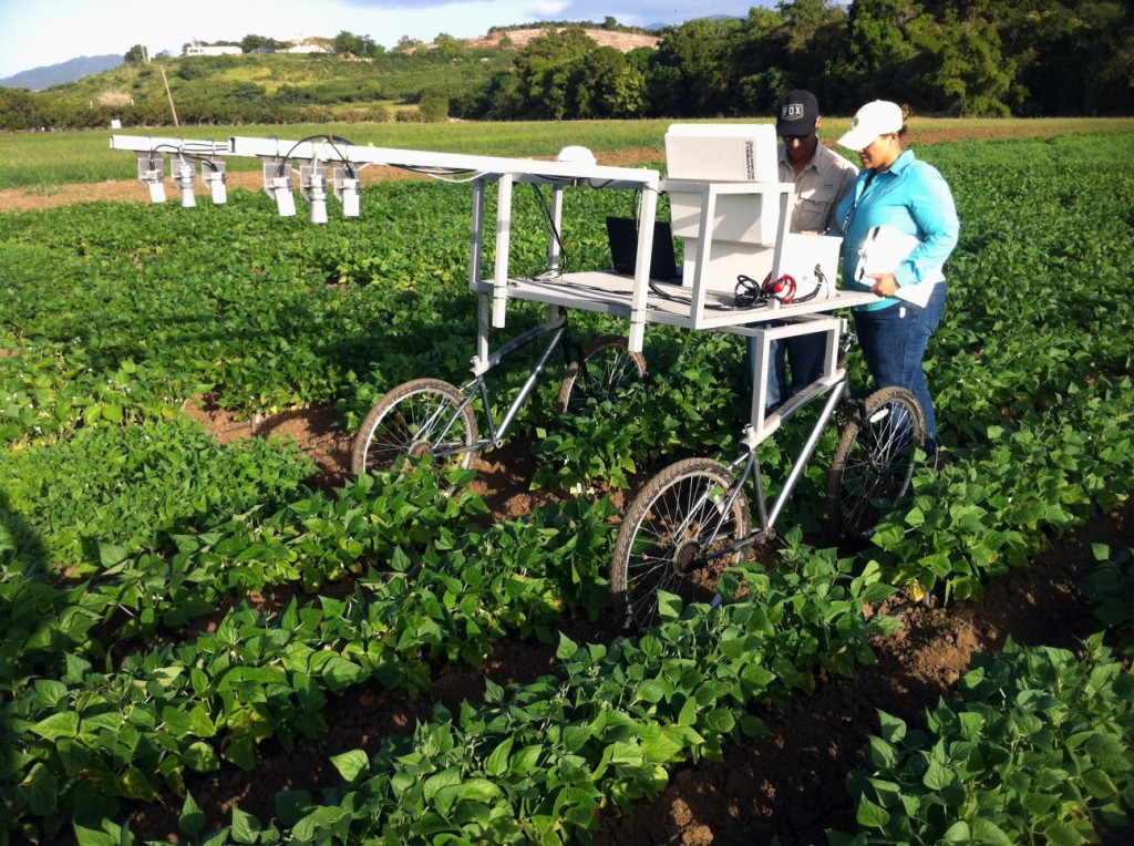 The design of the field data collection cart includes a bar for turning the wheels of two bicycles to facilitate movement through the field. Computer, GPS, sensors, and datalogger equipment are mounted on the cart for the collection of field data (as per White and Conley, 2013).